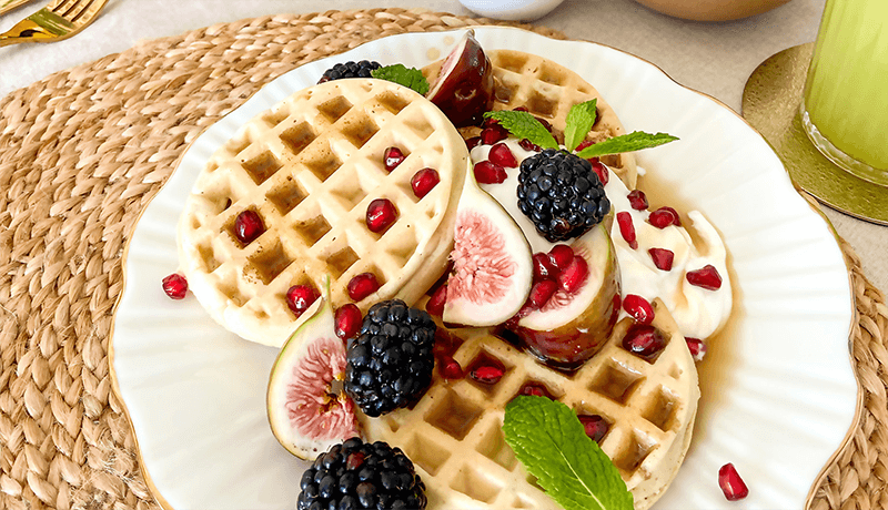 fig and berry waffles garnished with pomegranate