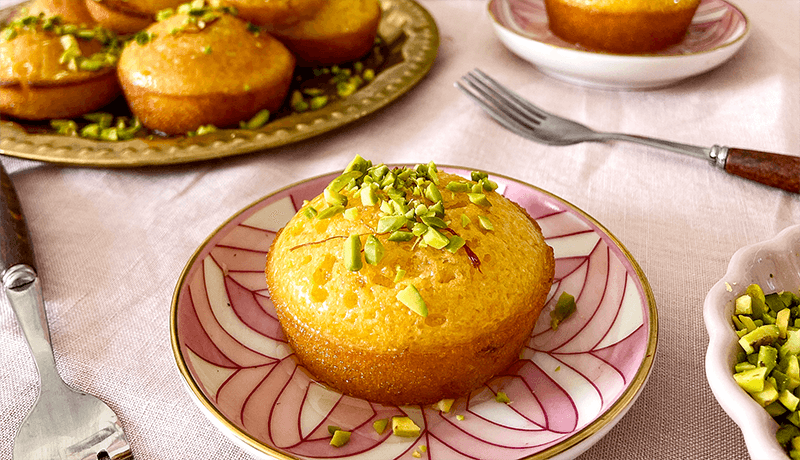 saffron orange tea cakes topped with pistachios served with fork